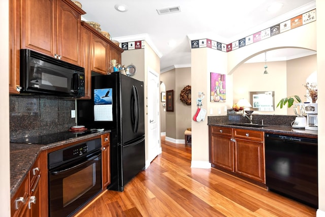 kitchen featuring tasteful backsplash, black appliances, sink, crown molding, and light wood-type flooring