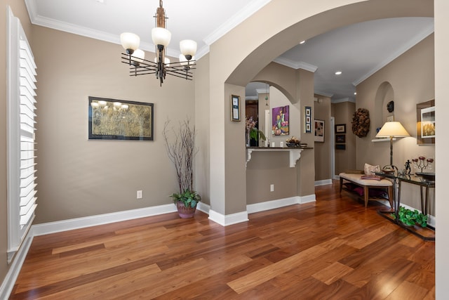 interior space with hardwood / wood-style flooring, a chandelier, and ornamental molding