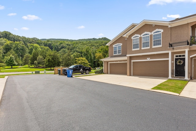 view of property exterior with a garage and a balcony