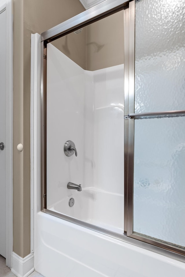 bathroom featuring shower / bath combination with glass door