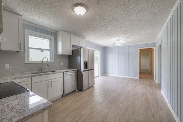 kitchen with appliances with stainless steel finishes, a sink, and ornamental molding