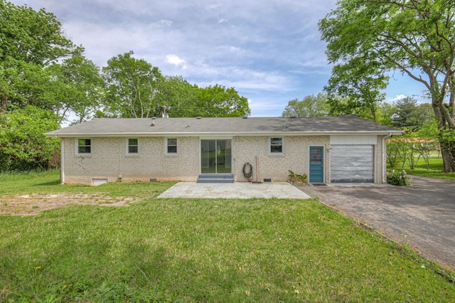 rear view of house with an attached garage, brick siding, a yard, driveway, and crawl space