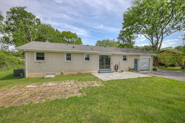 back of house featuring crawl space, brick siding, a yard, and an attached garage