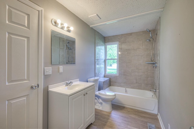 bathroom with visible vents, toilet, vanity, a textured ceiling, and wood finished floors