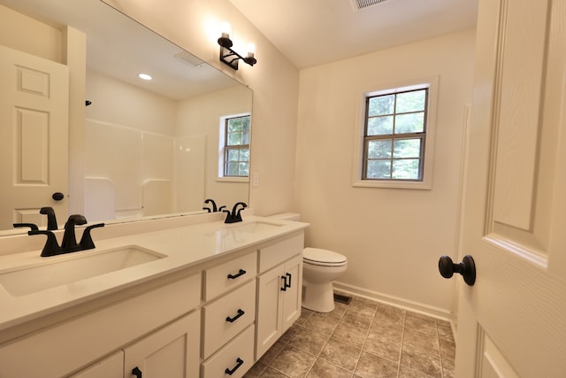 bathroom with tile patterned floors, double sink vanity, and toilet