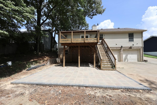 back of house featuring a garage, a deck, and a patio area