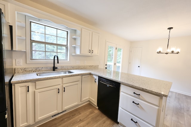 kitchen featuring black dishwasher, light wood-type flooring, sink, and kitchen peninsula