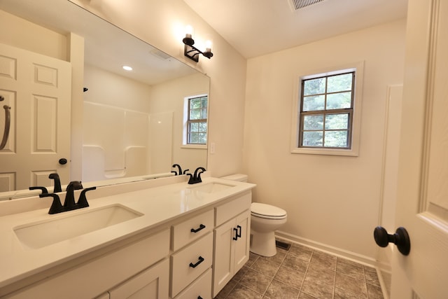 bathroom featuring tile patterned floors, double vanity, and toilet