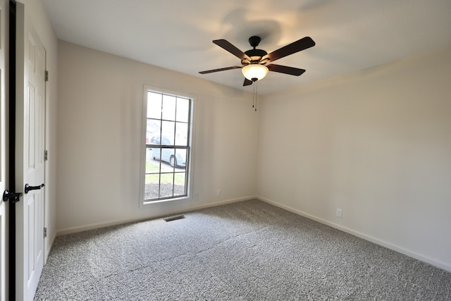 carpeted spare room featuring ceiling fan