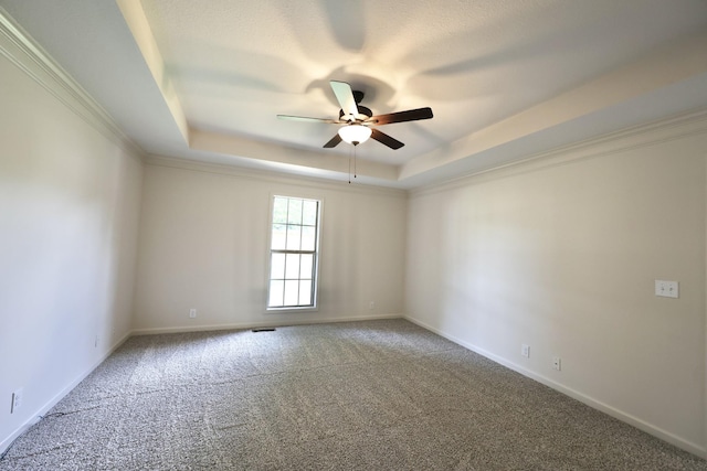 carpeted empty room with a raised ceiling, crown molding, and ceiling fan