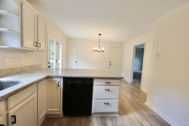 kitchen featuring an inviting chandelier, kitchen peninsula, light hardwood / wood-style floors, light stone countertops, and dishwasher