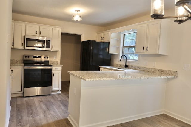 kitchen featuring stainless steel appliances, pendant lighting, and white cabinets