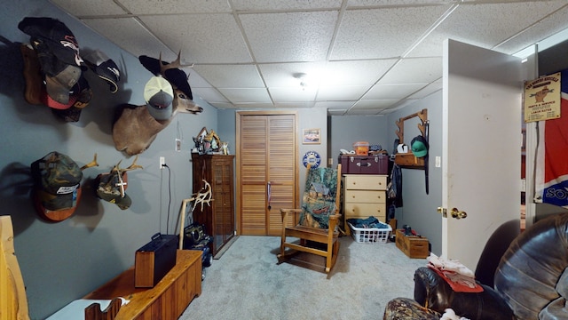 carpeted bedroom with a drop ceiling and a closet