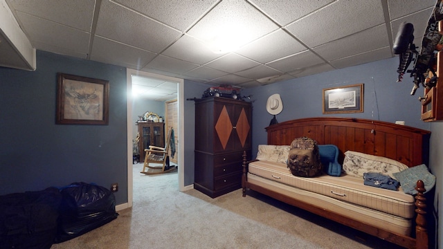 carpeted bedroom featuring a drop ceiling