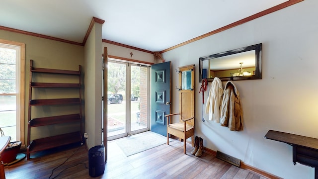 entryway with crown molding and hardwood / wood-style floors