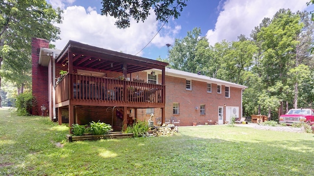 rear view of house featuring a lawn and a wooden deck