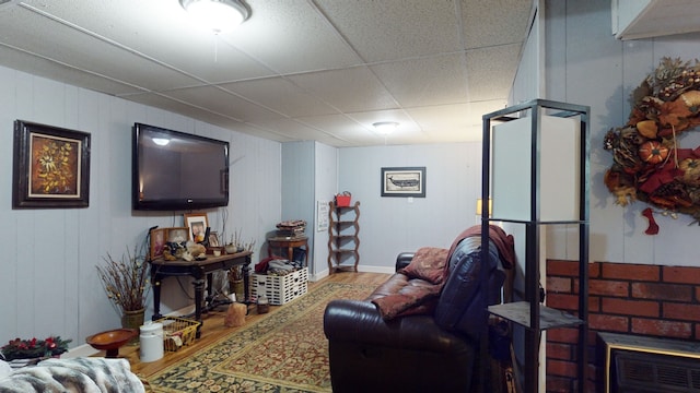 living room featuring a drop ceiling and hardwood / wood-style floors