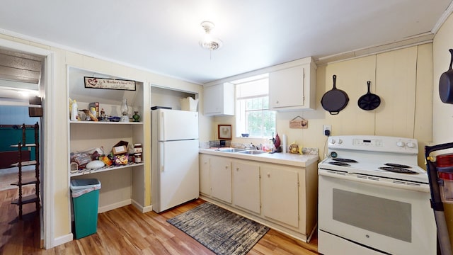 kitchen with white appliances, cream cabinets, light hardwood / wood-style floors, sink, and ornamental molding