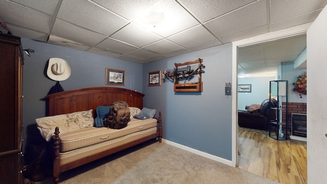 bedroom with light carpet and a paneled ceiling