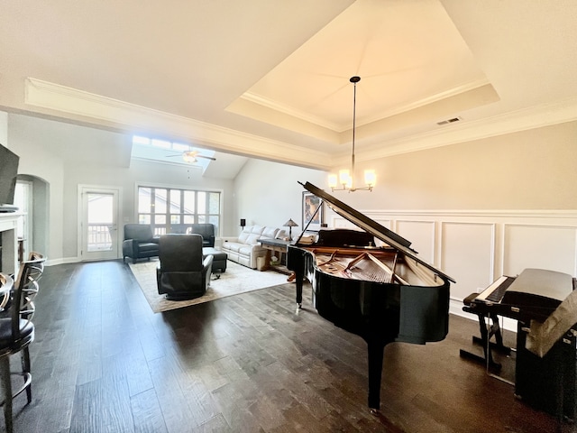 miscellaneous room featuring a tray ceiling, crown molding, ceiling fan with notable chandelier, and dark hardwood / wood-style floors