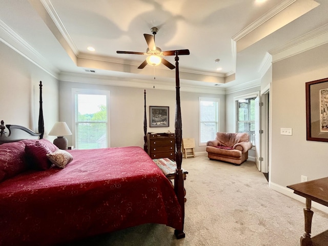 bedroom with crown molding, light colored carpet, a raised ceiling, and multiple windows