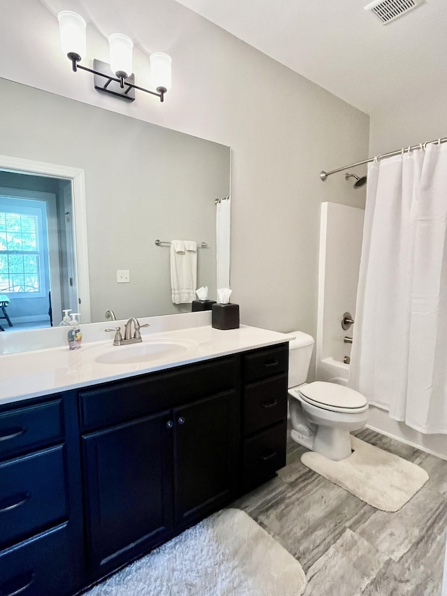 full bathroom with vanity, wood-type flooring, shower / bathtub combination with curtain, and toilet