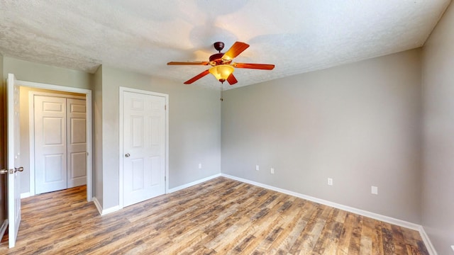 unfurnished bedroom with ceiling fan, light hardwood / wood-style floors, and a textured ceiling