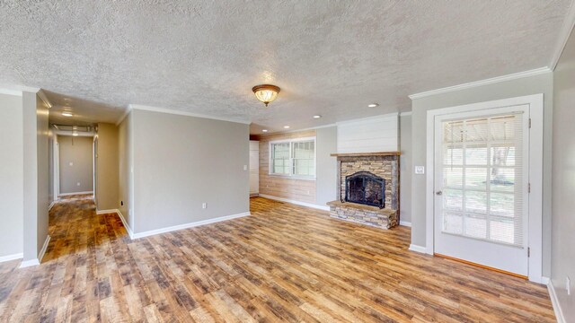 unfurnished living room featuring a fireplace, ornamental molding, plenty of natural light, and light wood-type flooring