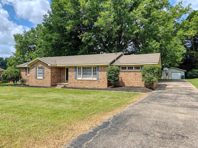 single story home featuring a garage, an outdoor structure, and a front lawn