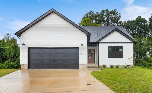 modern inspired farmhouse featuring a garage and a front lawn