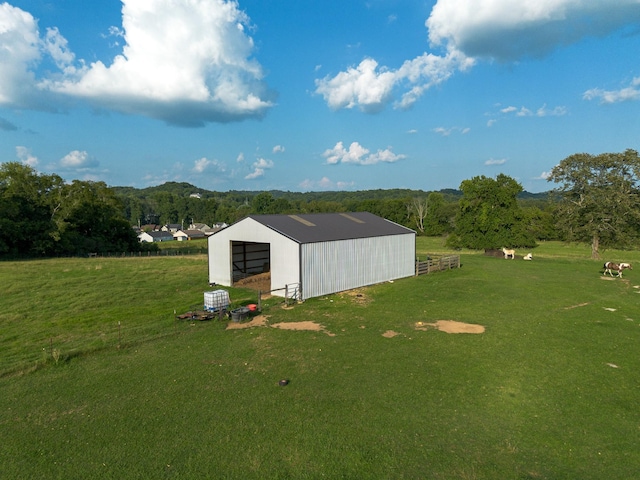 view of pole building with a rural view and a lawn