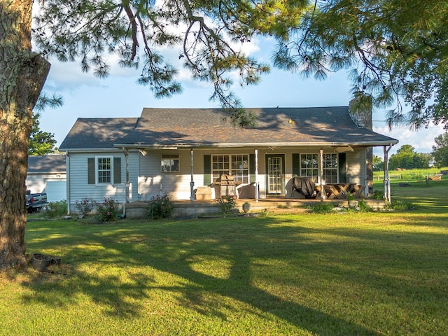 view of front facade with a porch, a chimney, and a front lawn