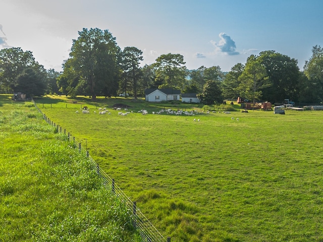 view of yard with a rural view and fence