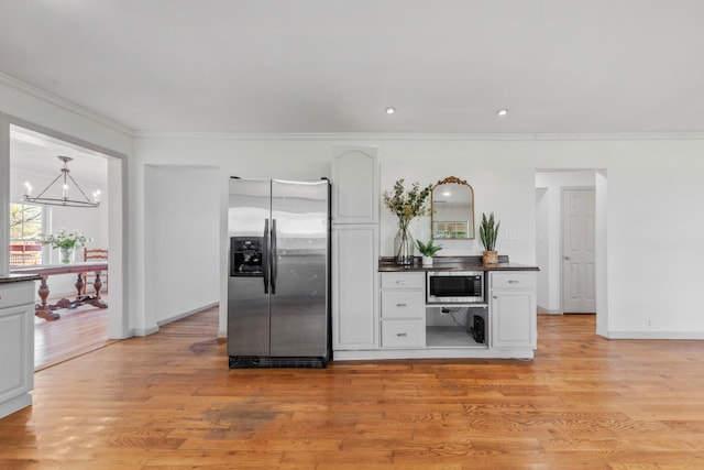 kitchen with crown molding, dark countertops, appliances with stainless steel finishes, white cabinets, and light wood-type flooring