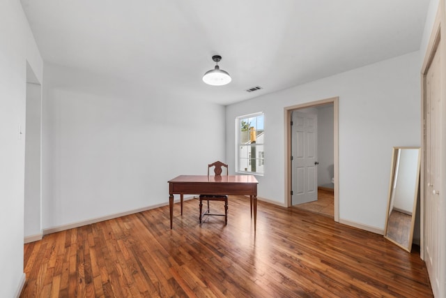 office area with hardwood / wood-style flooring, visible vents, and baseboards
