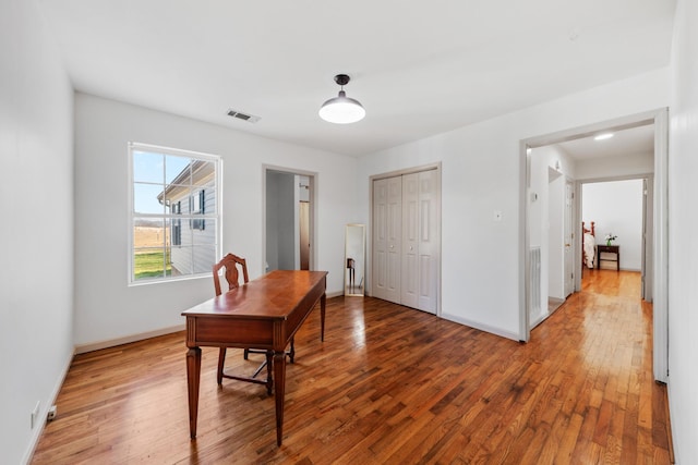 office with hardwood / wood-style floors, visible vents, and baseboards