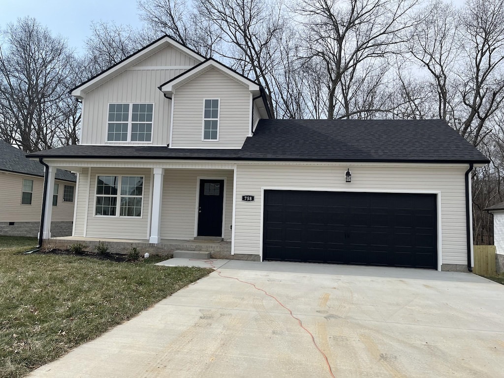 view of front of home featuring a porch, a garage, and a front lawn