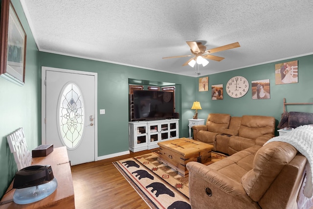 living room with crown molding, ceiling fan, hardwood / wood-style floors, and a textured ceiling