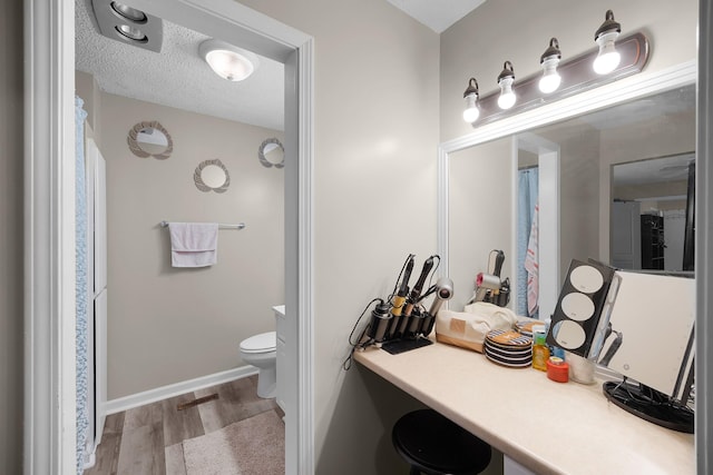 bathroom featuring vanity, hardwood / wood-style floors, a textured ceiling, and toilet