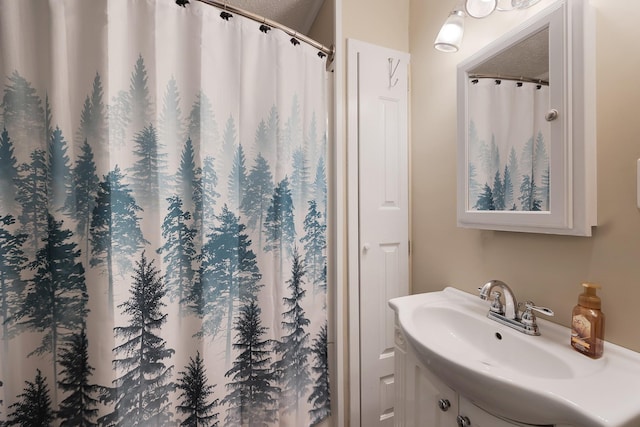 bathroom with a shower with shower curtain and sink