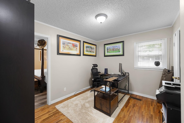 home office with crown molding, light hardwood / wood-style floors, and a textured ceiling