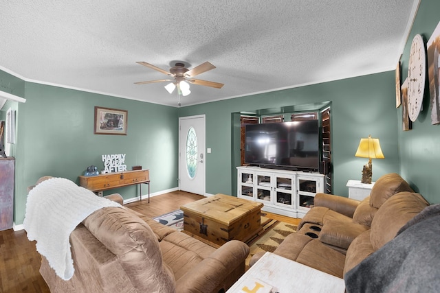 living room featuring wood-type flooring, ceiling fan, and crown molding