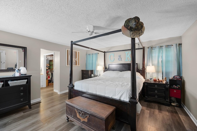 bedroom featuring hardwood / wood-style floors, vaulted ceiling, a textured ceiling, and ceiling fan