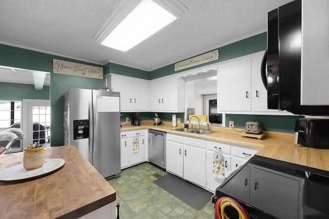 kitchen featuring white cabinetry, sink, a textured ceiling, and appliances with stainless steel finishes