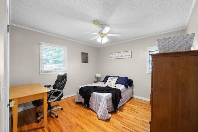 bedroom with ceiling fan, ornamental molding, a textured ceiling, and light wood-type flooring