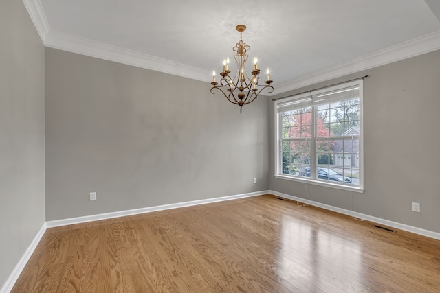 spare room featuring crown molding, an inviting chandelier, and light hardwood / wood-style flooring