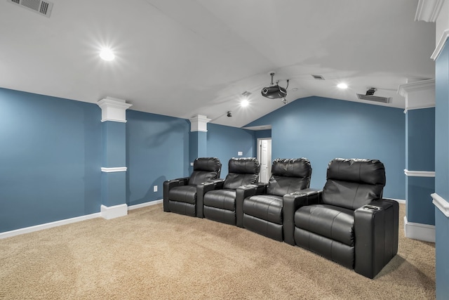 carpeted cinema room with ornate columns and vaulted ceiling