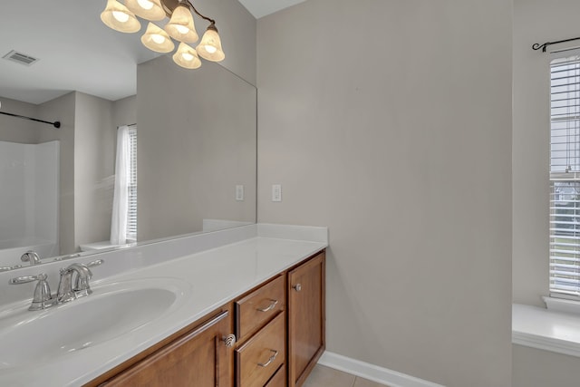 bathroom with walk in shower, tile patterned floors, vanity, and a wealth of natural light