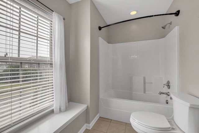 bathroom featuring tile patterned flooring, toilet, and washtub / shower combination