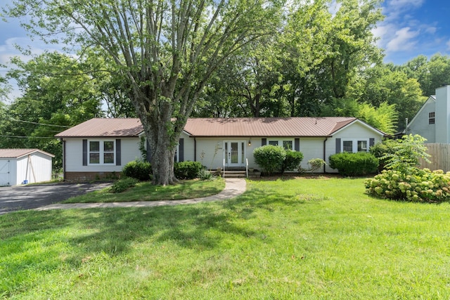 single story home with an outbuilding and a front lawn